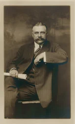 George Kessler. Formeel zittend portret, onderwerp naar voren gericht